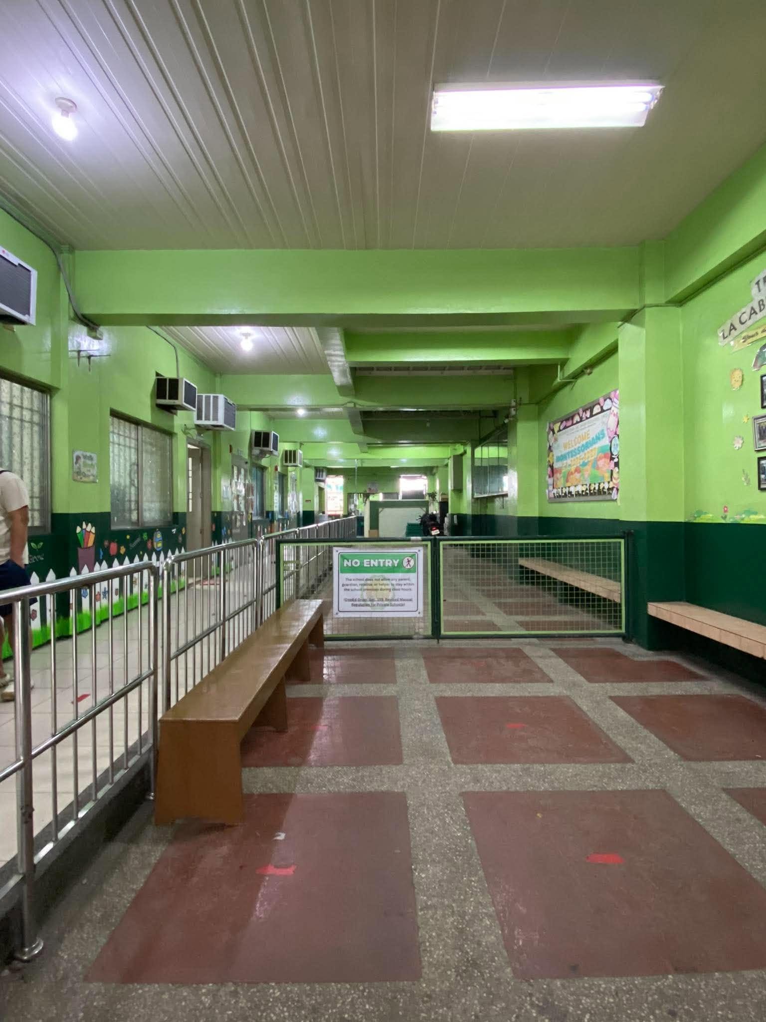 Bright green school hallway with benches and a welcome board